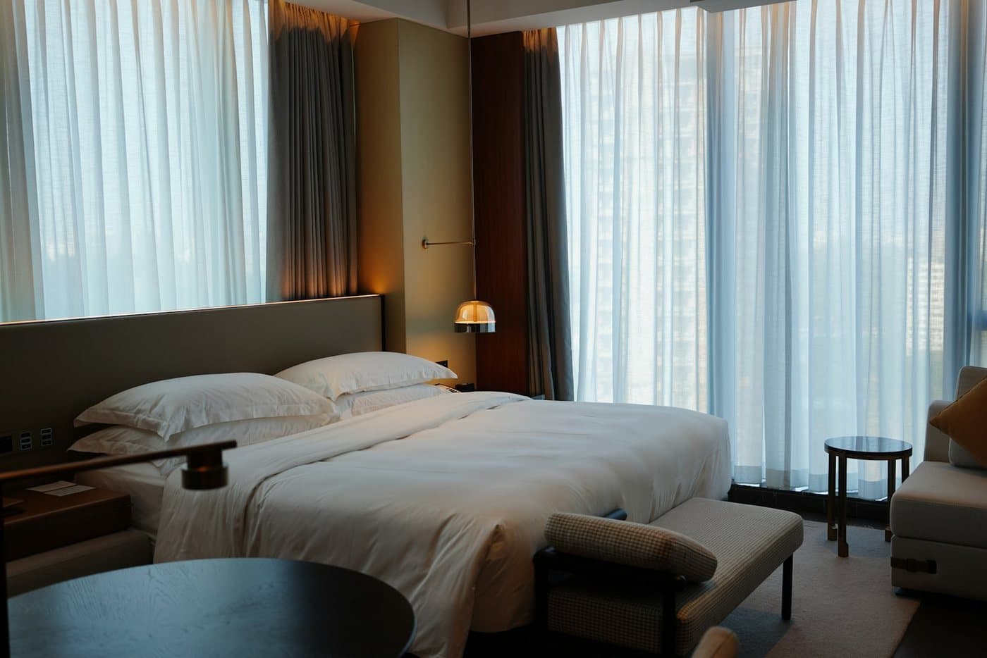 Hotel room with a bed beside tall windows